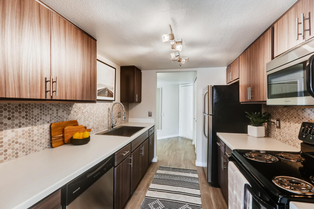 Kitchen with white counter tops, brown cabinets, and tile backsplash