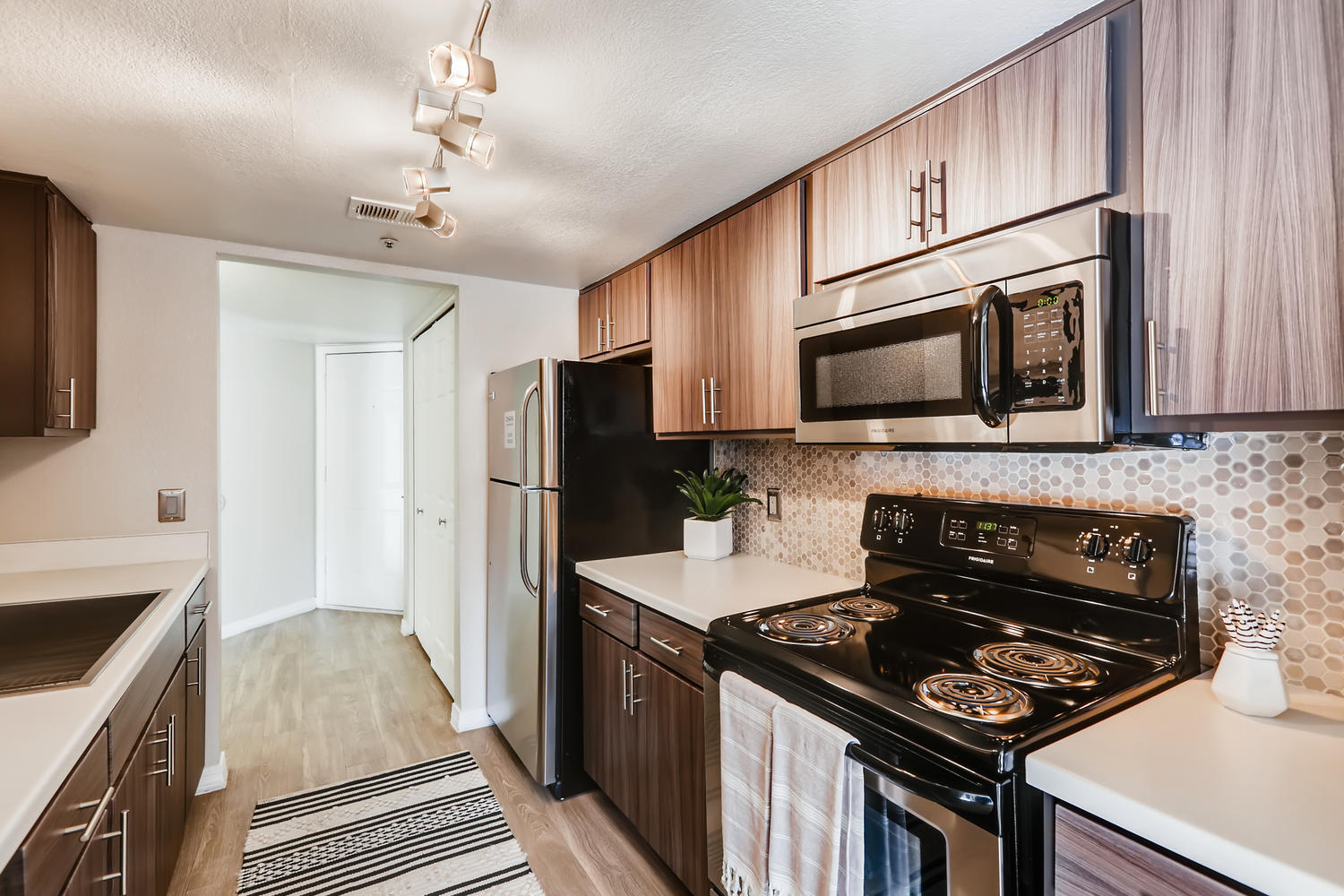 Kitchen view with a view of hallway and brown cabinets