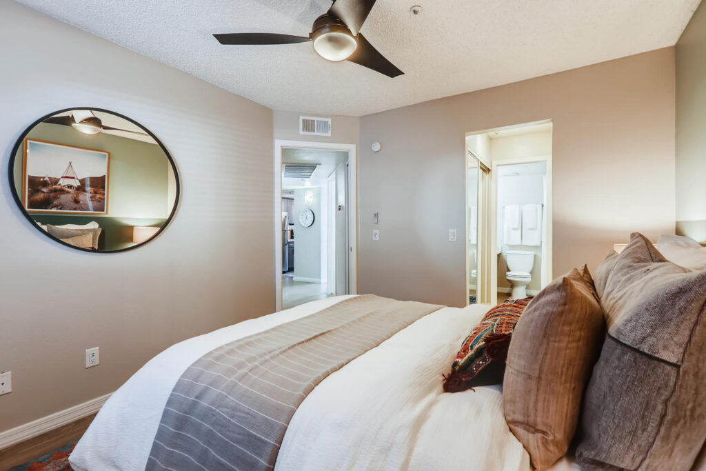 staged bedroom with ceiling fan and private bathroom
