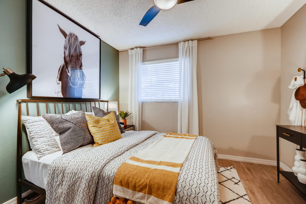 bedroom with ceiling fan and green accent wall