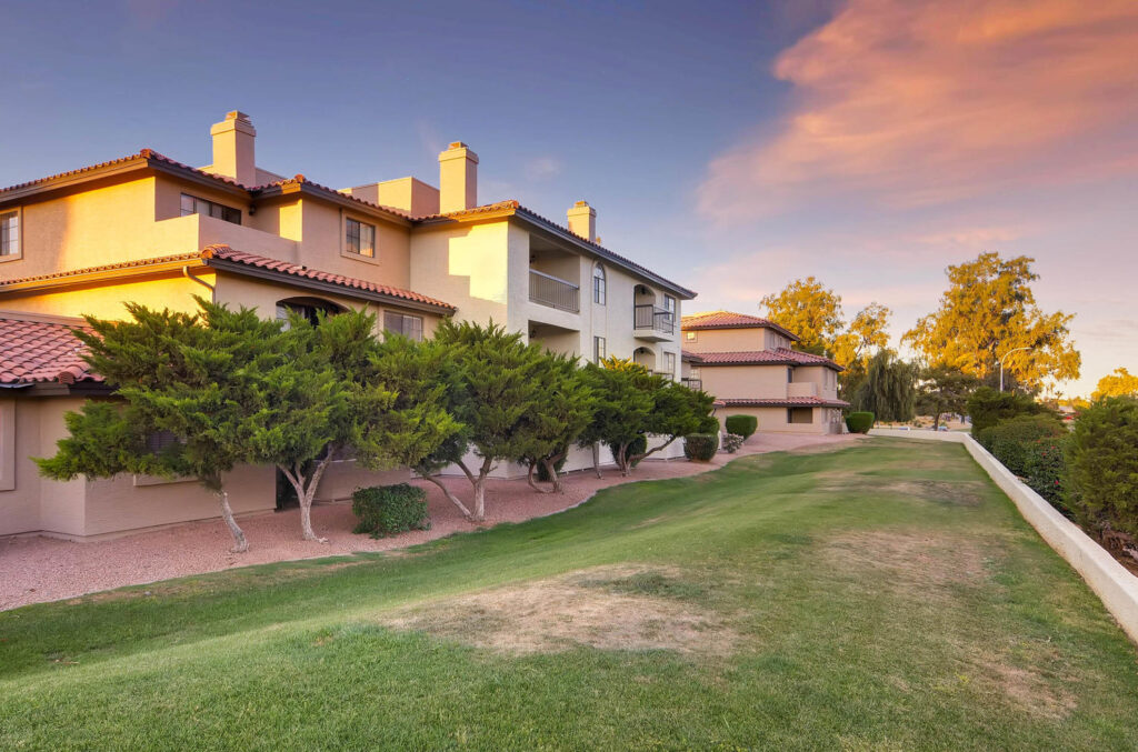exterior of buildings with large grassy field and trees