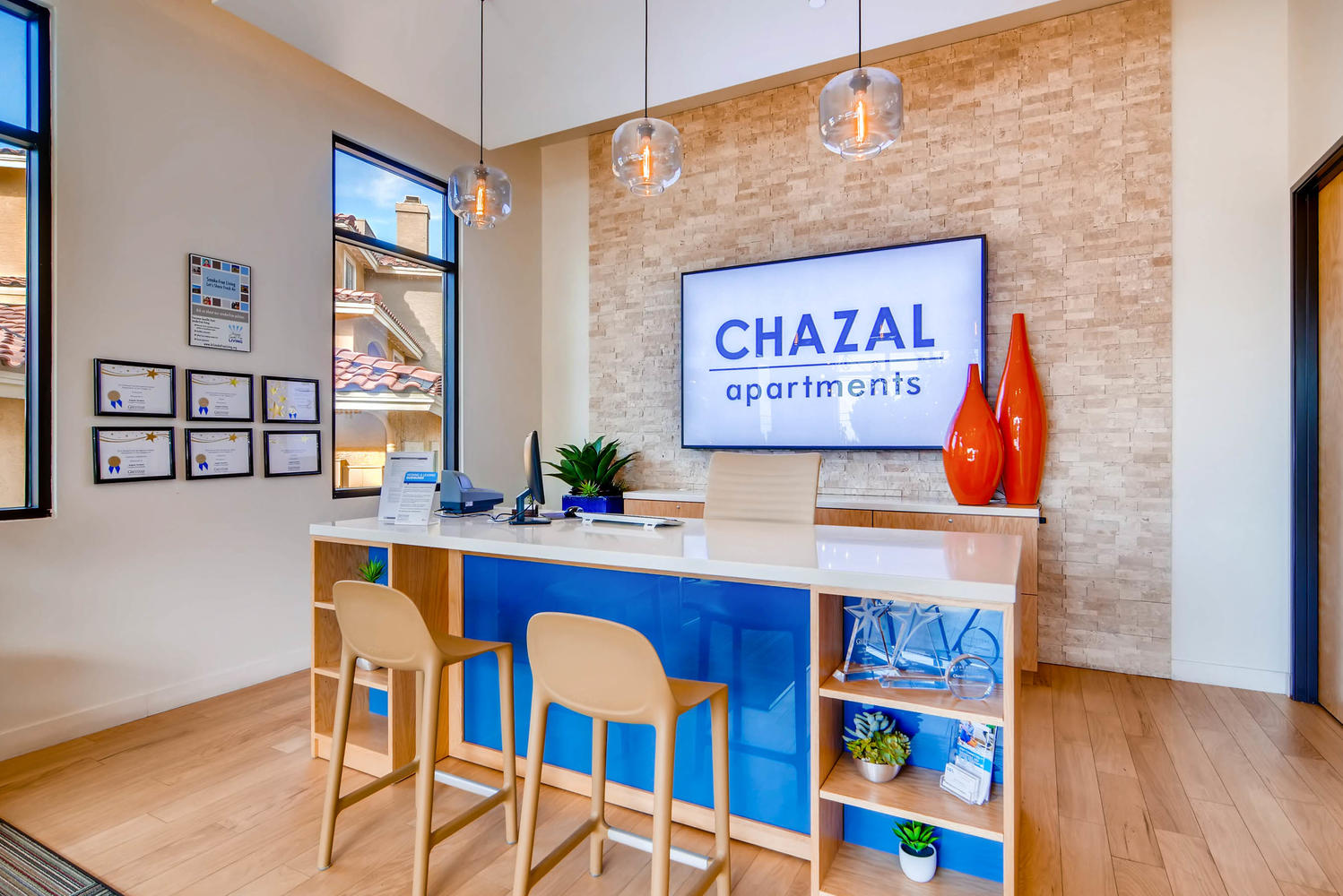 The front desk with the name Chazal Apartments on the sign on the wall