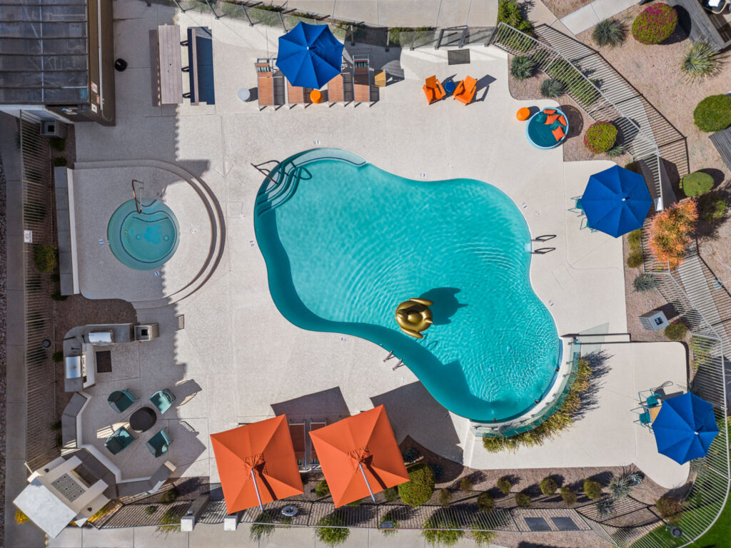 pool with deck seating and tables with umbrellas